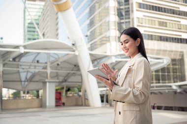 Modern şehirde tablet kullanan güzel bir iş kadınının portresi.