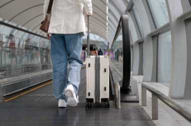 Close-up woman foot walking with suitcase , check in at International airport , vacation travel and transportation concept