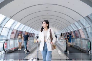 A young beautiful woman walking with suitcase , check in at International airport , vacation travel and transportation concept