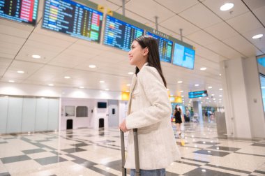 A young beautiful woman walking with suitcase , check in at International airport , vacation travel and transportation concept