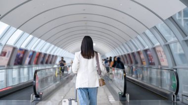 A young beautiful woman walking with suitcase , check in at International airport , vacation travel and transportation concept