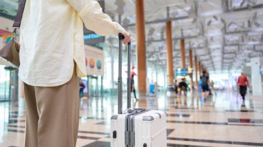 Close-up woman hand walking with suitcase , check in at International airport , vacation travel and transportation concept