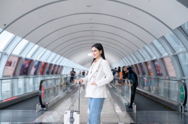 A young beautiful woman walking with suitcase , check in at International airport , vacation travel and transportation concept