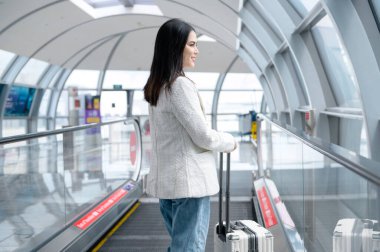 A young beautiful woman walking with suitcase , check in at International airport , vacation travel and transportation concept