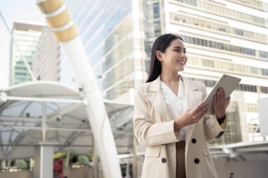 Modern şehirde tablet kullanan güzel bir iş kadınının portresi.