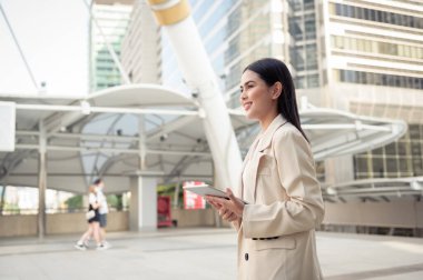 Modern şehirde tablet kullanan güzel bir iş kadınının portresi.