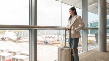 A young beautiful woman walking with suitcase , check in at International airport , vacation travel and transportation concept