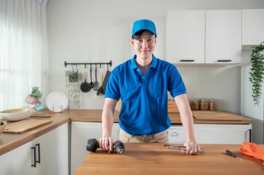 An Asian young Technician service man wearing blue uniform checking electrical appliances in home