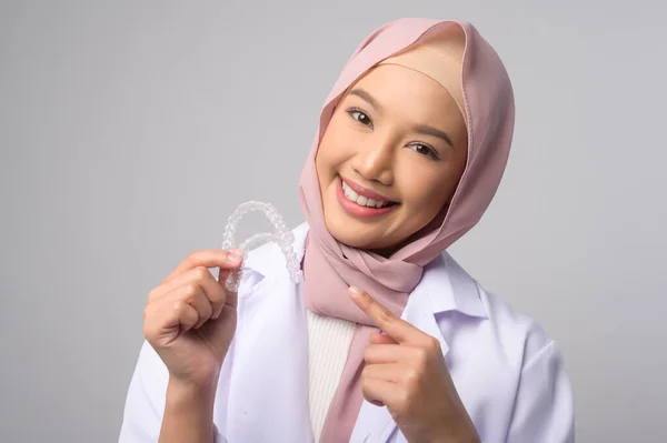 一名年轻的穆斯林女牙医在白人背景演播室 牙科保健和牙齿矫正概念的基础上 手持无创矫形器架 — 图库照片