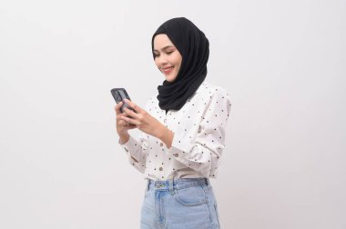 Beautiful musllim woman with hijab using smartphone over white background, technology concept. 		