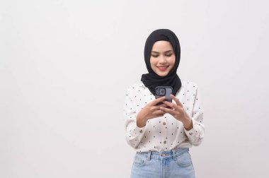 Beautiful musllim woman with hijab using smartphone over white background, technology concept. 		
