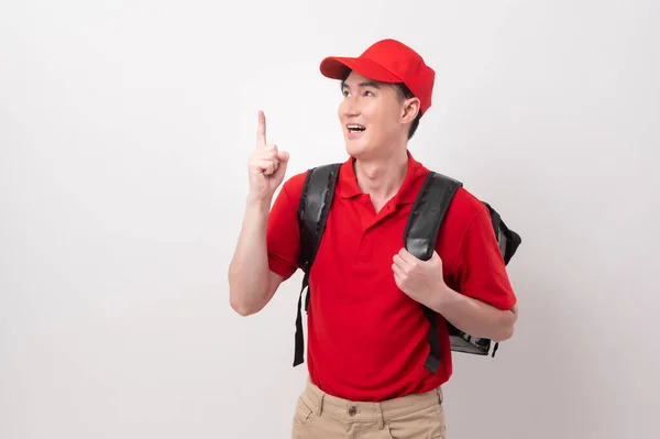 アジアの若い食品配達男は白い背景に笑みを浮かべて食品手荷物を運ぶ赤い制服を着て — ストック写真