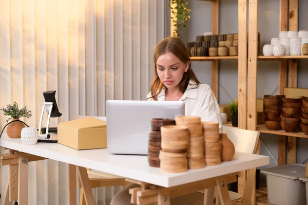 stock image A young pretty woman entrepreneur checking and packaging craft products selling to customers in her shop