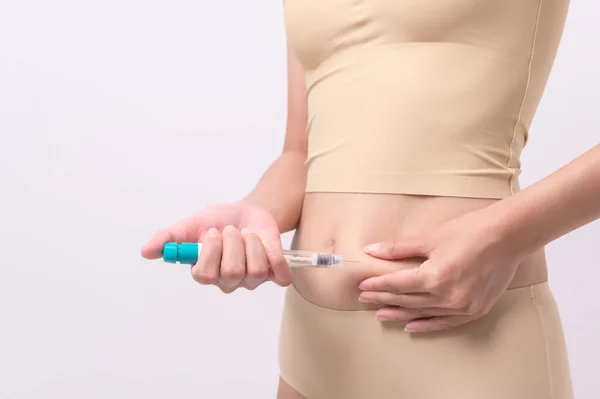 stock image Close up woman using IVF treatment injection on belly to prepare reproductive fertility , Ovulation stimulation .	