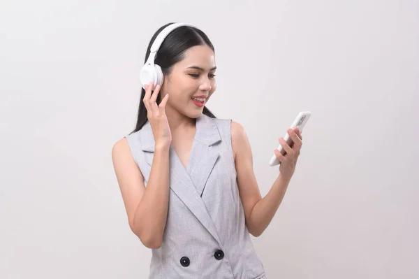 一个戴耳机的年轻女人 带着白色背景的音乐 — 图库照片