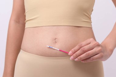 Beyaz arkaplanda Ovalasyon (LH) testi ya da (HCG Hamilelik Testi) kullanan kadını kapat