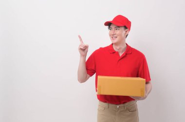 Asyalı genç teslimatçı beyaz arka planda kırmızı üniforma giyiyor.