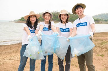 Asyalı gençlik cemiyeti gönüllüleri çöp torbalarıyla doğayı temizliyor.