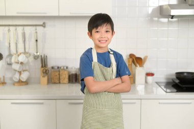Evdeki mutfakta gülümseyen akıllı çocuğun portresi.