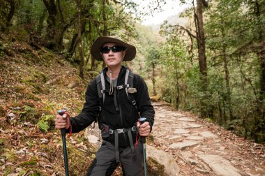 Genç bir gezgin orman yolunda yürüyor, Nepal