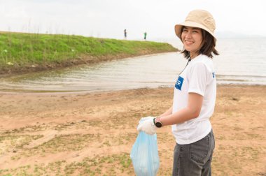 Asyalı gençlik cemiyeti gönüllüleri çöp torbalarıyla doğayı temizliyor.
