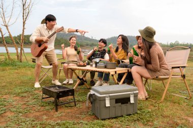 Bir grup genç Asyalı doğal kamp alanında kamp yapmayı seviyor.