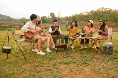 Bir grup genç Asyalı doğal kamp alanında kamp yapmayı seviyor.