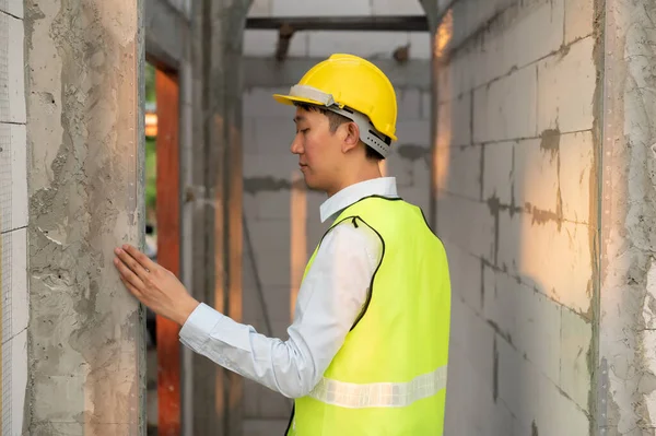 stock image An Asian Engineering man wearing safety helmet checking construction site analyzing about project progress 