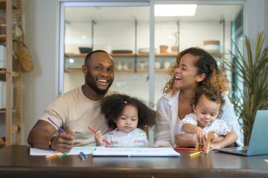 Mutlu Afrika kökenli Amerikalı ebeveynler evde kızlarıyla oynayıp resim çiziyor. 