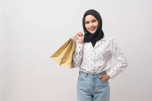 白い背景スタジオ ショッピング 金融の概念上のクレジットカードとショッピングバッグを保持ヒジャーブと美しいイスラム教徒の女性 — ストック写真