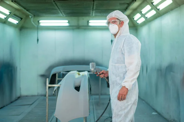 stock image Caucasian man is using painting gun in repair mechanic painting shop