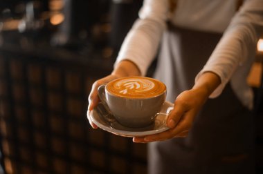 Kahveci elinde Latte sanat modern kahve dükkanında içmeye hazır.