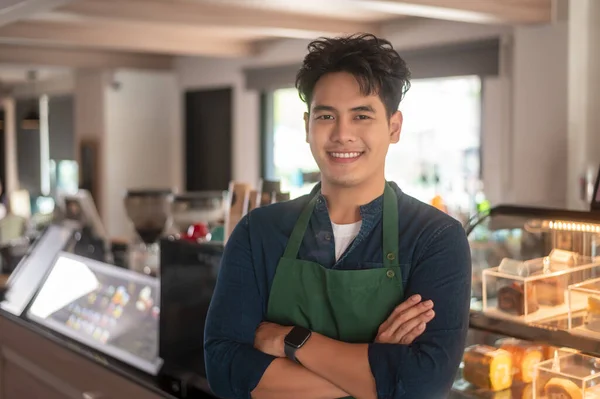 An Asian man entrepreneur or barista working in modern coffee shop , concept small business