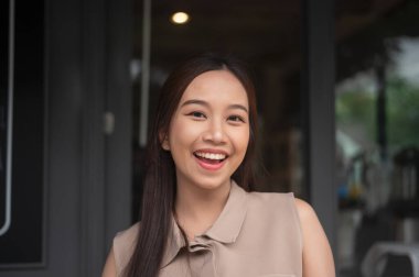 Gülümseyen genç ve güzel Asyalı kadının yüzünü kapat.  