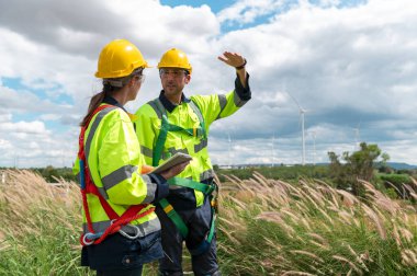 İnsanlar kafalarına koruyucu bir kask takıyor. Tablet analitik mühendisliği verileri kullanıyorlar.