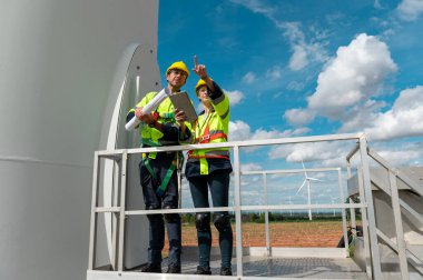 İnsanlar kafalarına koruyucu bir kask takıyor. Tablet analitik mühendisliği verileri kullanıyorlar.