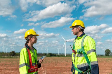 İnsanlar kafalarına koruyucu bir kask takıyor. Tablet analitik mühendisliği verileri kullanıyorlar.