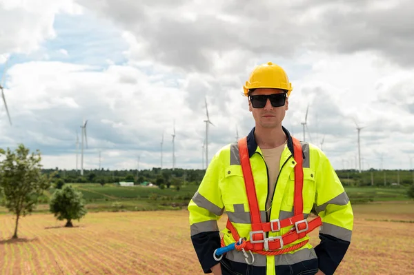 Portrait of smart engineer with protective helmet at electrical turbines field