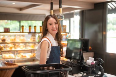 Markette çalışan Asyalı genç bir kasiyer kadın.