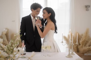 Gelin ve damat düğün töreninde şampanya kadehleri tutuyorlar.