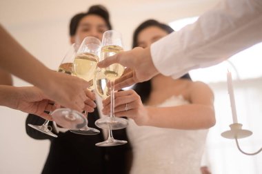 Düğünde eller şampanya kadehlerini tutarken.