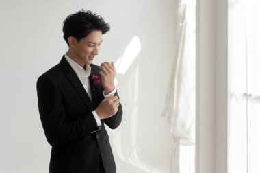 Takım elbiseli yakışıklı damadın portresi, düğün törenine hazırlanıyor.