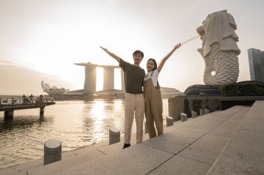SINGAPORE - 28 / 12 / 2022: Marina Körfezi Sands Oteli önündeki Merlion Fountain 'da genç Asyalı aşk turisti sürüsü. 