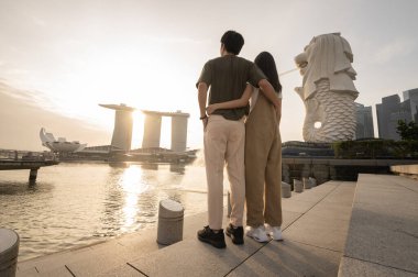 SINGAPORE - 28 / 12 / 2022: Marina Körfezi Sands Oteli önündeki Merlion Fountain 'da genç Asyalı aşk turisti sürüsü. 
