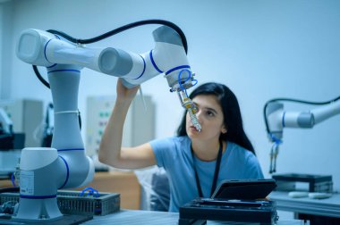 Robot El Programlama ve Yönlendirme, Endüstriyel Robot Tasarımı, Yüksek Teknoloji Tesisi, Modern Makine Öğrenme ile çalışan kadın robotik mühendisi. Seri Üretim Otomatik.