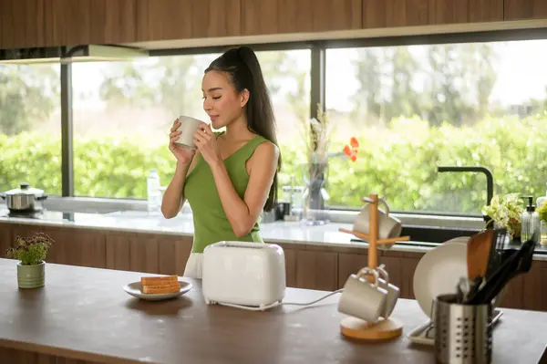 Asian woman preparing coffee and toast bread for breakfast at the kitchen table in the morning