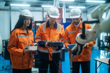 Robot El Programlama ve Yönlendirme, Endüstriyel Robot Tasarımı, Yüksek Teknoloji Tesisi, Modern Makine Öğrenme ile çalışan bir grup robot mühendisi. Seri Üretim Otomatik.