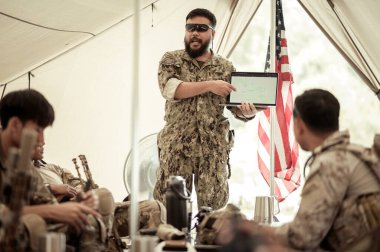 Kampta operasyon yapmayı planlayan kamuflaj üniformalı askerler, askeri harekat eğitimi almış askerler.