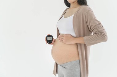 Hamile kadın kan şekerini dijital glikoz ölçer, sağlık bakımı, ilaç, diyabet, glisemi konsepti kullanarak kontrol ediyor.