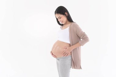 Güzel hamile bir kadın nemlendirici sürüyor, göbeğinde gerilme izi kremi, kısırlık tedavisi, tüp bebek, gelecekteki annelik konsepti.